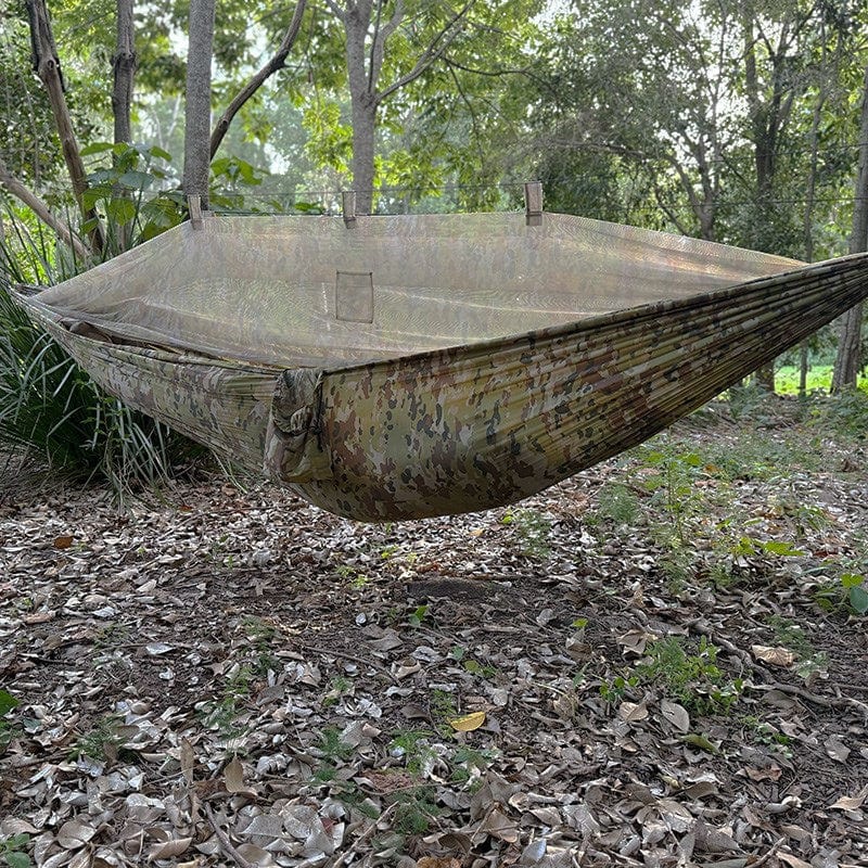 Spartan Artemis Ultra-Light Bug-Net Hammock with camo pattern set up in a forest, showcasing its integrated bug net and nylon construction.