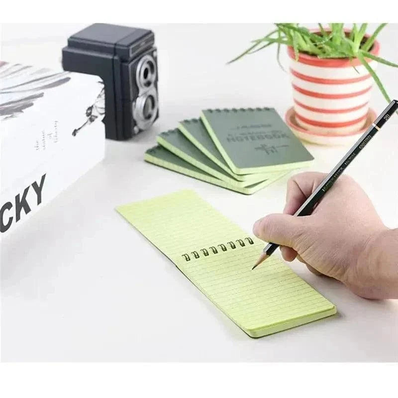 Compact waterproof notebooks being used, showcasing their durability and versatility for outdoor and everyday use.