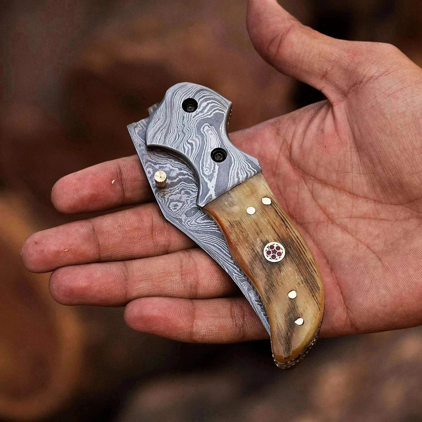 Damascus Steel Folding Knife with Ram White Horn handle, handcrafted for durability and elegance.