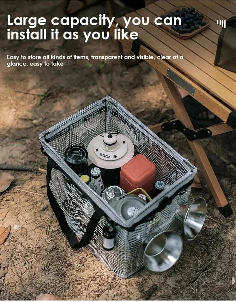 Camping Storage Bag with high capacity, holding camping gear and cookware, on forest ground next to a wooden table.