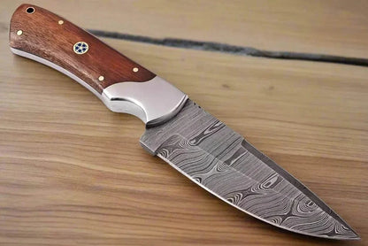 Damascus steel hunting knife with rose wood handle and pattern welded blade.