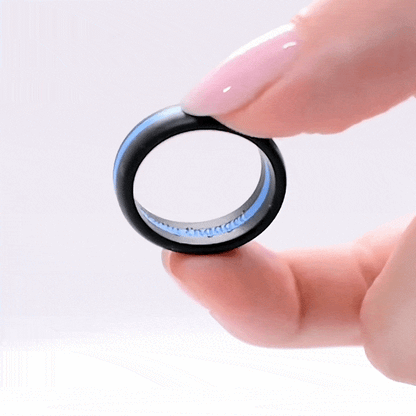 Black silicone ring with a striking blue stripe, held between fingers.