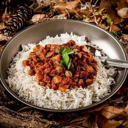 Chickpea curry on rice in a metal bowl, ideal hiking food.