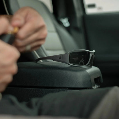 Edge Eyewear Hamel sunglasses with G-15 Vapor Shield lens on car seat, showcasing high-impact ballistic protection and anti-fog technology.