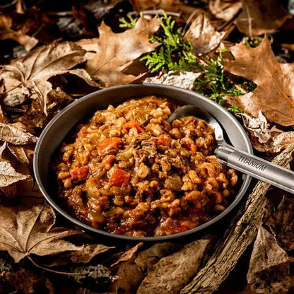 Best hiking food featuring tender lamb and pearl barley in a bowl amidst autumn leaves.