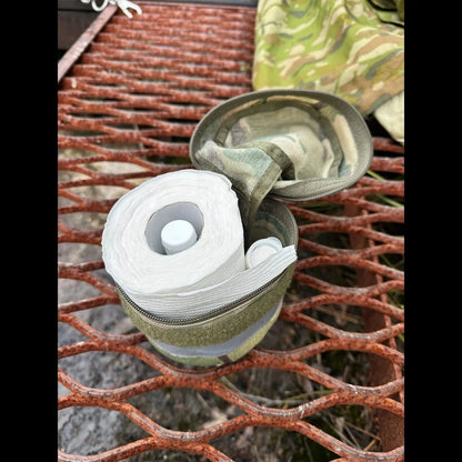 Toilet roll storage holder with nylon casing on outdoor metal surface.