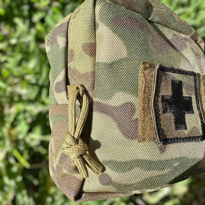 Military-grade Tactical First Aid Kit in Multicam pouch with Velcro First Aid cross patch displayed.