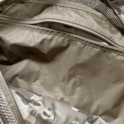Tactical duffle bag interior with large zipped pocket and camouflage lining.