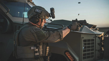 SWAT officer wearing Edge Eyewear Rolling Thunder shooting from behind an armored vehicle.