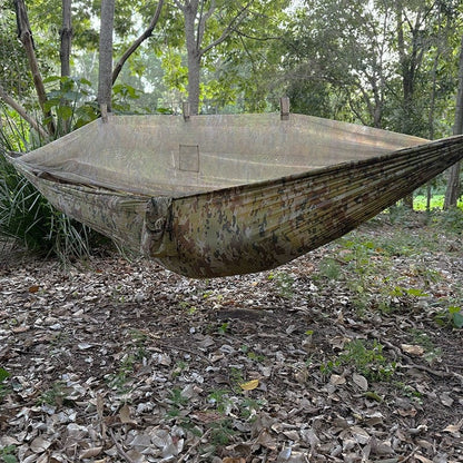 Spartan Artemis Ultra-Light Bug-Net Hammock with camo pattern set up in a forest, showcasing its integrated bug net and nylon construction.