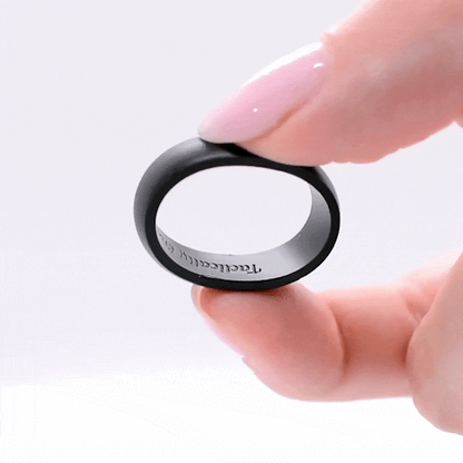 Classic black silicone ring with engraved message held between fingertips.