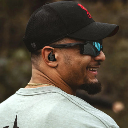 Man wearing Axil X20 Earplugs for hearing protection outdoors.