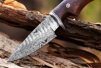 Damascus Steel Hunting Knife with rosewood handle on a log.