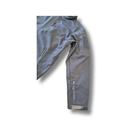 Tactical softshell jacket with zippered sleeve pocket, durable fabric, and water-resistant features.
