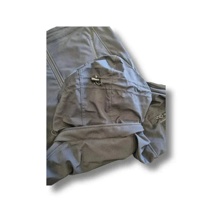 Tactical softshell jacket by Valhalla with reinforced elbows, multiple utility pockets, and adjustable hood, designed for durability and wind resistance.