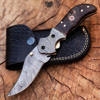 Damascus Steel Folding Knife with black horn handle and crocodile leather sheath.