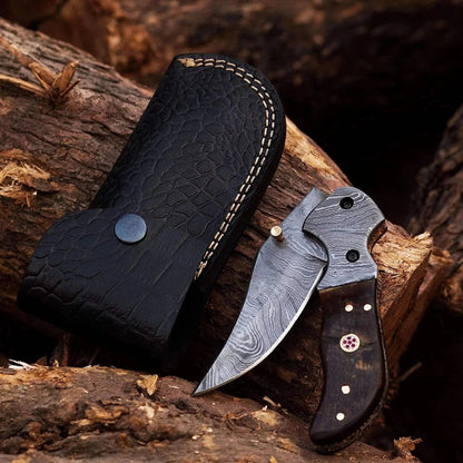 Damascus Steel Folding Knife with Crocodile Leather Sheath on Wood Background