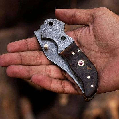 Damascus Steel Folding Knife with Ram Black Horn handle, showcasing intricate Damascus pattern and craftsmanship.