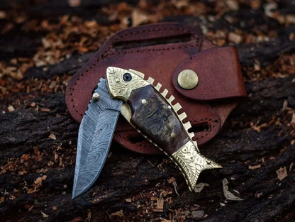 Fish Style Damascus Steel Folding Knife with intricate blade pattern and leather sheath.