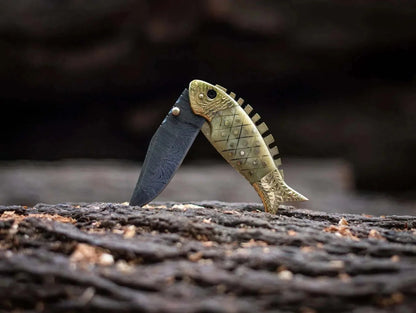 Fish Style Damascus Steel Folding Knife with unique fish-shaped handle and Damascus blade displayed on wood.