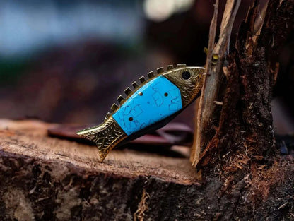 Fish Style Damascus Steel Folding Knife with blue and gold fish-shaped handle on wood surface.