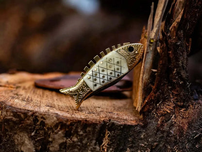 Fish Style Damascus Steel Folding Knife with bone and brass handle, displayed on a wooden surface, featuring intricate craftsmanship and unique design.