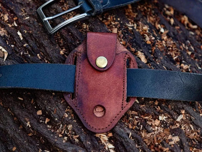 Leather sheath for Damascus Steel Folding Knife on wood background.