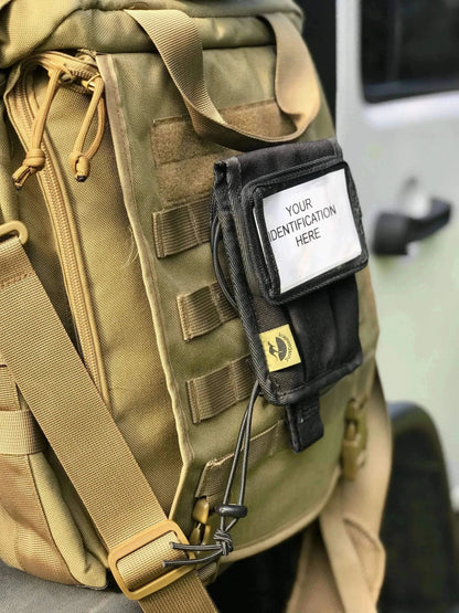 Velcro ID card holder attached to a backpack with clear window for identification display.