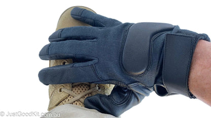 Tactical glove in use, featuring Kevlar and goatskin construction with Velcro cuff for secure fit.