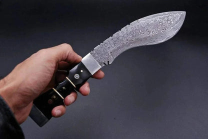 Damascus Steel Kukri Style Knife with intricately patterned blade, held in hand.